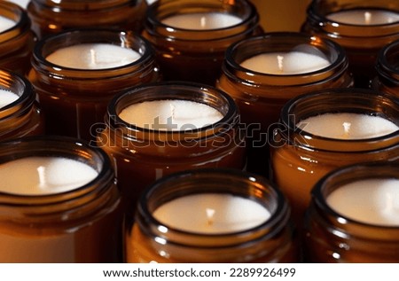A set of different aroma Soy and coconut wax candles in brown glass jars. Scented handmade candle. Soy candles in a Amber jar. Aromatherapy and relax in spa and home. Close up. Macro. Horizontal.