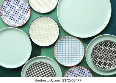 Set of different ceramic plates on green table