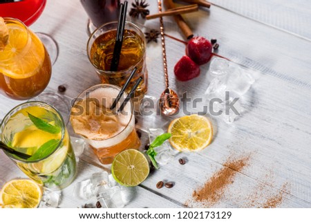 A set of different colored cocktails at the bar