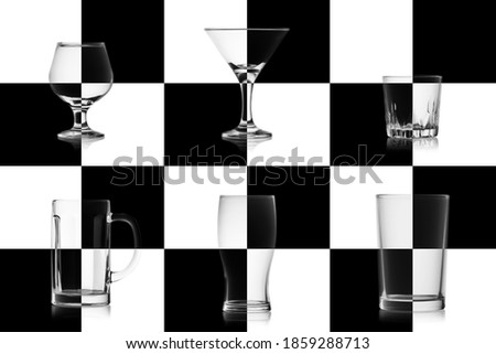 Set of different empty glasses for alcoholic drinks isolated on the chessboard. Glassware game concept for alcohol.
