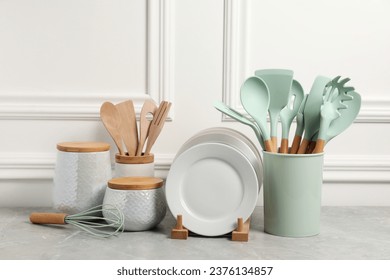 Set of different kitchenware on light gray table near white wall - Shutterstock ID 2376134857