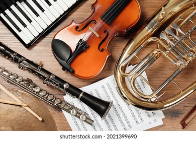 Set of different musical instruments on wooden background, flat lay