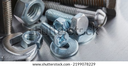 set of different nuts, bolts, screws, washers and drill bits,thread tap and mill cutters on steel plate background. Locksmithing deal.