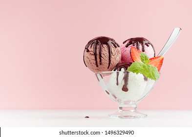 Set Of Different Refreshing Classic Creamy Ice Cream Balls In Bowl With Chocolate Sauce, Mint, Spoon, Strawberry On White Wooden Table, Pink Background.