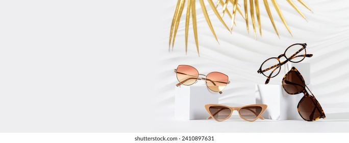 Set of different sunglasses and eyeglasses on podiums on white background. Summer fashion eyeglasses collection. Sunglasses sale, discount, promotion banner. Minimal still life, copy space - Powered by Shutterstock