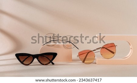 Set of different sunglasses and eyeglasses on podiums on beige background. Summer fashion eyeglasses collection. Sunglasses sale, discount, promotion banner. Minimal style flat lay, copy space