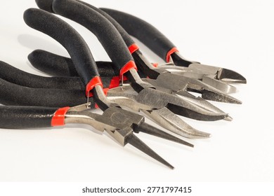 Set of different types of pliers and side cutters isolated on black background.