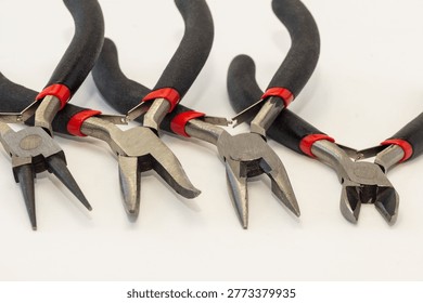 Set of different types of pliers and side cutters isolated on black background.