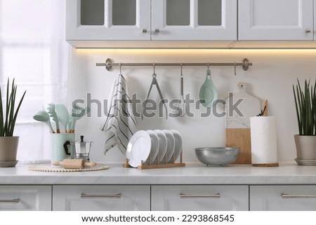 Set of different utensils and dishes on countertop in kitchen