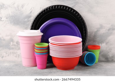 Set of disposable plastic dishware on light grey table