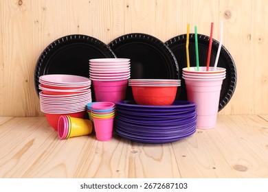 Set of disposable plastic tableware on light wooden table