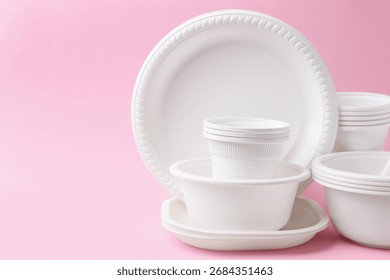 Set of disposable plastic tableware on pink background, closeup. Space for text