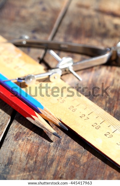 Set\
of drawing tools on wooden background under\
sunlight