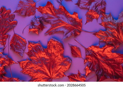 Set of dry red metallic leaves on violet background with neon light. Autumn natural concept. Top view, flat lay. - Powered by Shutterstock