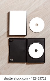 Set Dvd Or Cd Disc Cover Case Mockup With Open Plastic Box. Template Disc With White Isolated Free Space For Design. Mock Up With Black Package For Compact Or Dvd Disc. On Wooden Table Background. Top