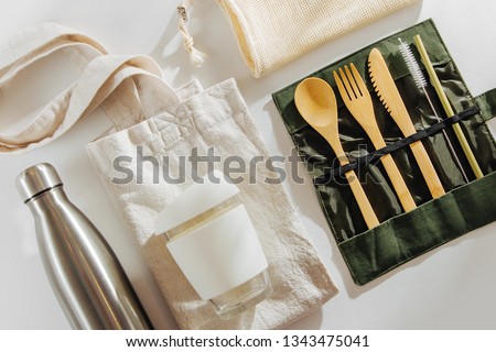 Set of Eco friendly bamboo cutlery, eco bag  reusable coffee mug  and  water bottle. Sustainable lifestyle.  Plastic free concept.