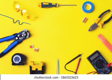 Set of electrician's tools on yellow background. Flat lay composition with electrician's tools and space for text yellow background