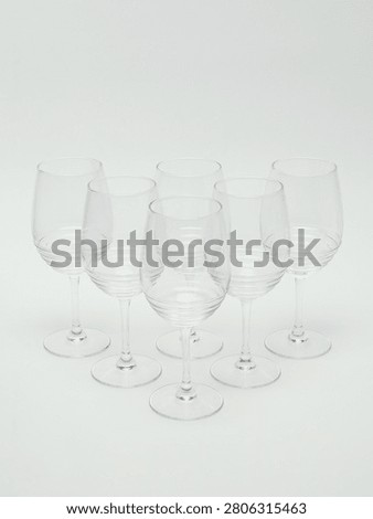 Set of empty clear glass stemware, including wine glasses and champagne flutes, isolated on white background.