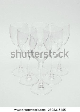 Set of empty clear glass stemware, including wine glasses and champagne flutes, isolated on white background.