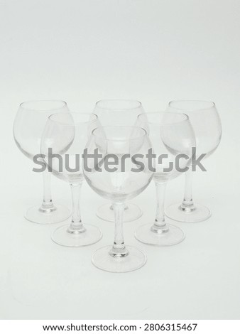 Set of empty clear glass stemware, including wine glasses and champagne flutes, isolated on white background.