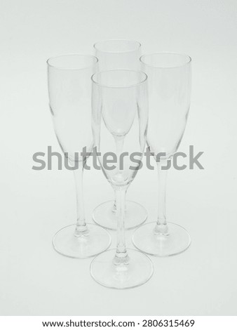 Set of empty clear glass stemware, including wine glasses and champagne flutes, isolated on white background.