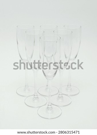 Set of empty clear glass stemware, including wine glasses and champagne flutes, isolated on white background.