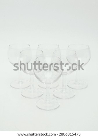 Set of empty clear glass stemware, including wine glasses and champagne flutes, isolated on white background.