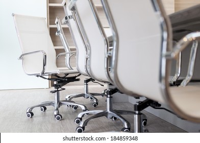 Set Of Empty Office Chairs Next To Long Table In Boardroom With Low Camera Angle