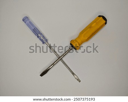 A set of essential tools: a flat-head screwdriver, a Phillips-head screwdriver, and a digital voltage tester