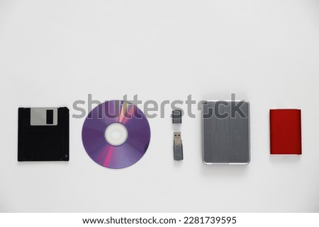 Set of external Storage media. Storage device evolution. Floppy disk, CD or DVD disk, USB flash drive, External hard disk drive, External SSD on white background, top view, flat lay.