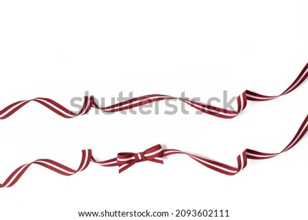 Set of fabric strings in latvian traditional colours. Twisted Flag of Latvia ribbon and bow isolated on a white background