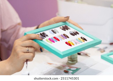 Set of false nails for manicure in the hands of a manicurist. Varnish color palette for nail painting. Colorful artificial nails. Testers nail Polish. - Powered by Shutterstock