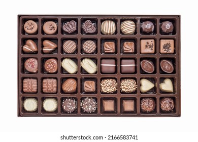 A Set Of Festive Chocolate Sweets Of Various Shapes And Designs In A Box Isolated On A White Background. View From Above. Top View