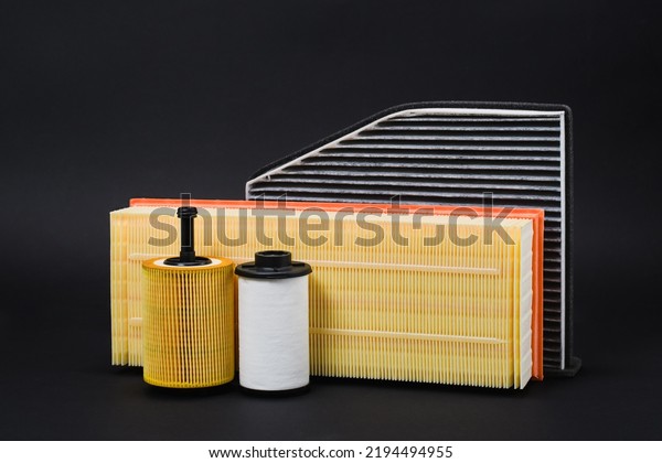 A set of filters for car service. Car spare\
parts on a black background.
