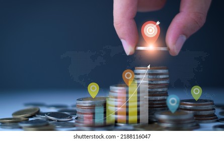 Set Financial Goals Concept. Businessman Is Tapping On Top Of Coins, Setting Business And Financial Goals, Saving Money, Investing Money, Growing Business Graph, Increasing Profit On Investment.