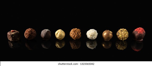 Set of fine chocolate candies White, dark and milk chocolate on black background with reflection, for banner