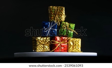 Set of five bright multi-colored boxes with holiday gifts on a dark background. Photo. Copy space. Close-up