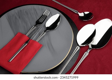 a set of flatware on red background with sppon and fork on a plate