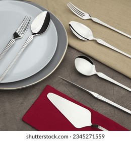 a set of flatware on table with sppon and fork on a plate