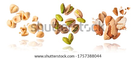 A set with Flying in air fresh raw whole and cracked pistachios, almonds and hazelnut isolated on white background. Concept of Pistachios almonds and hazelnut is torn to pieces close-up.