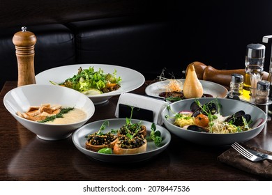 set of food, set table in an italian restaurant, Italian risotto with roasted chicken, snacks on dark wooden table. Italian food table, top view