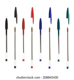 Set of four different color ballpoint pens with and without the plastic cap, isolated over the white background