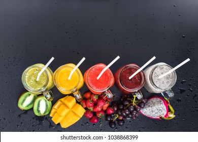 Set Fresh Range Color Juices Smoothie Green Yellow Red Violet White from Tropical Fruits Kiwi Mango Strawberry Grapes Dragon Jar Rainbow Dark Background Top View
