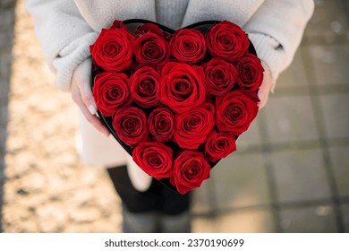 Set of fresh red rose buds in heart shaped box in woman's hands. Top view. Space for text - Powered by Shutterstock