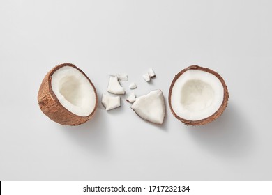 Set from freshly brocken ripe natural organic exotic coconut fruit on a light grey background with soft shadows and copy space. Vegan concept. Top view.