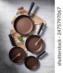 Set of frying or cooking pans. They are nonstick and iron cast. A set of pans from different size. Nonstick cookware is good for home usage only. The coating can be easily removed depend on quality