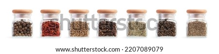 Set of glass jars with different spices on a white isolated background