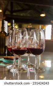 Set Of Glasses Of Ruby Port Wine On Glass Table