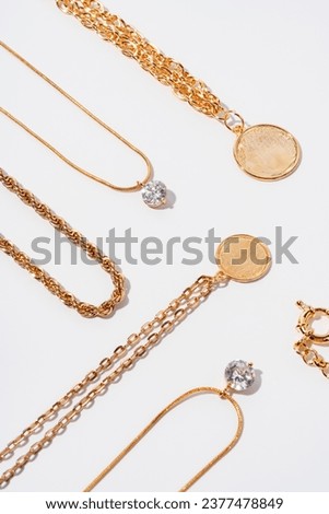 Set of gold chains with pendant on white background