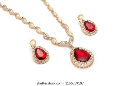 Set Of Gold Earrings And A Necklace With A Ruby Isolated On White